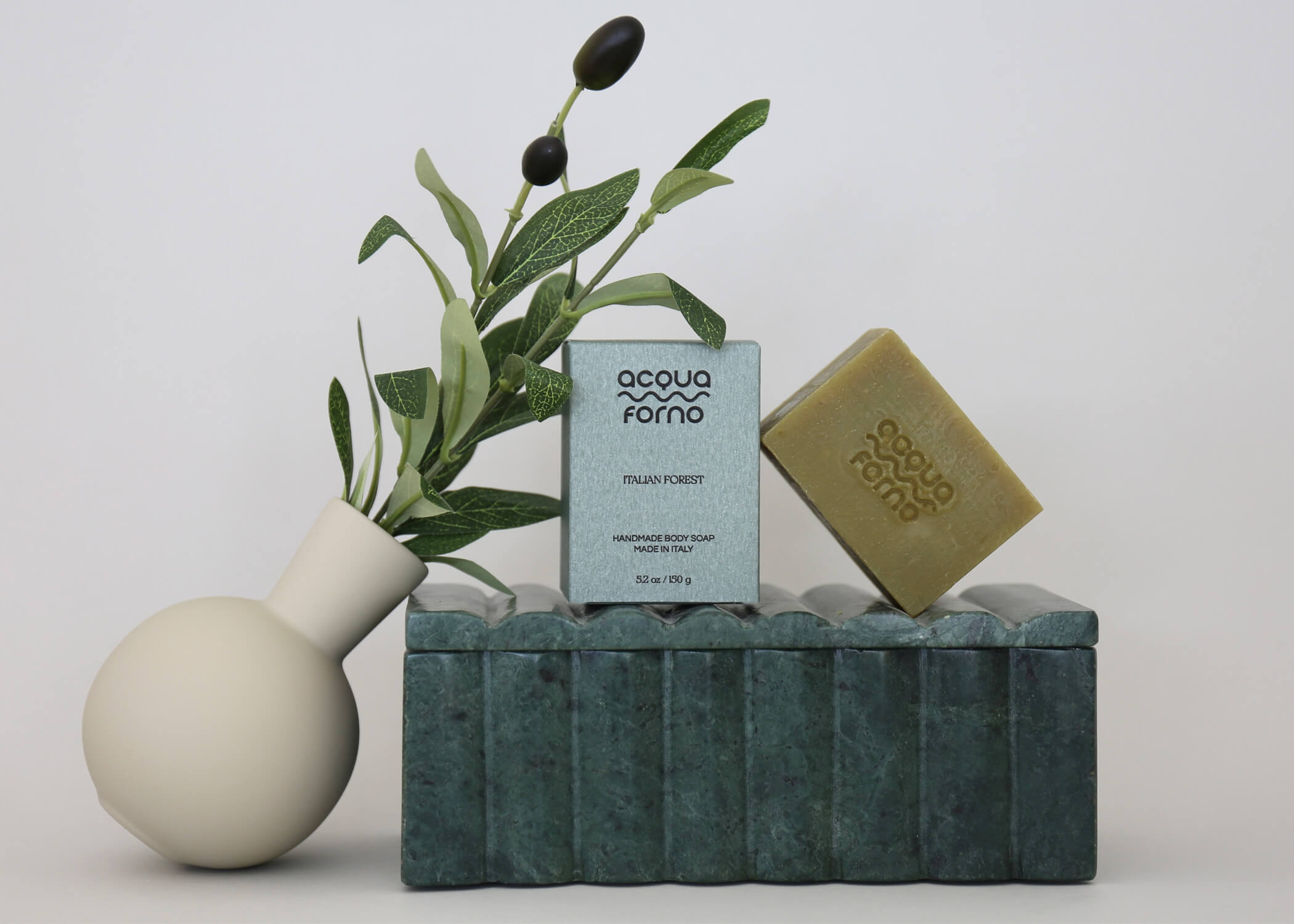 Sustainable Italian body care products — handmade soap and solid shampoo bars on natural background