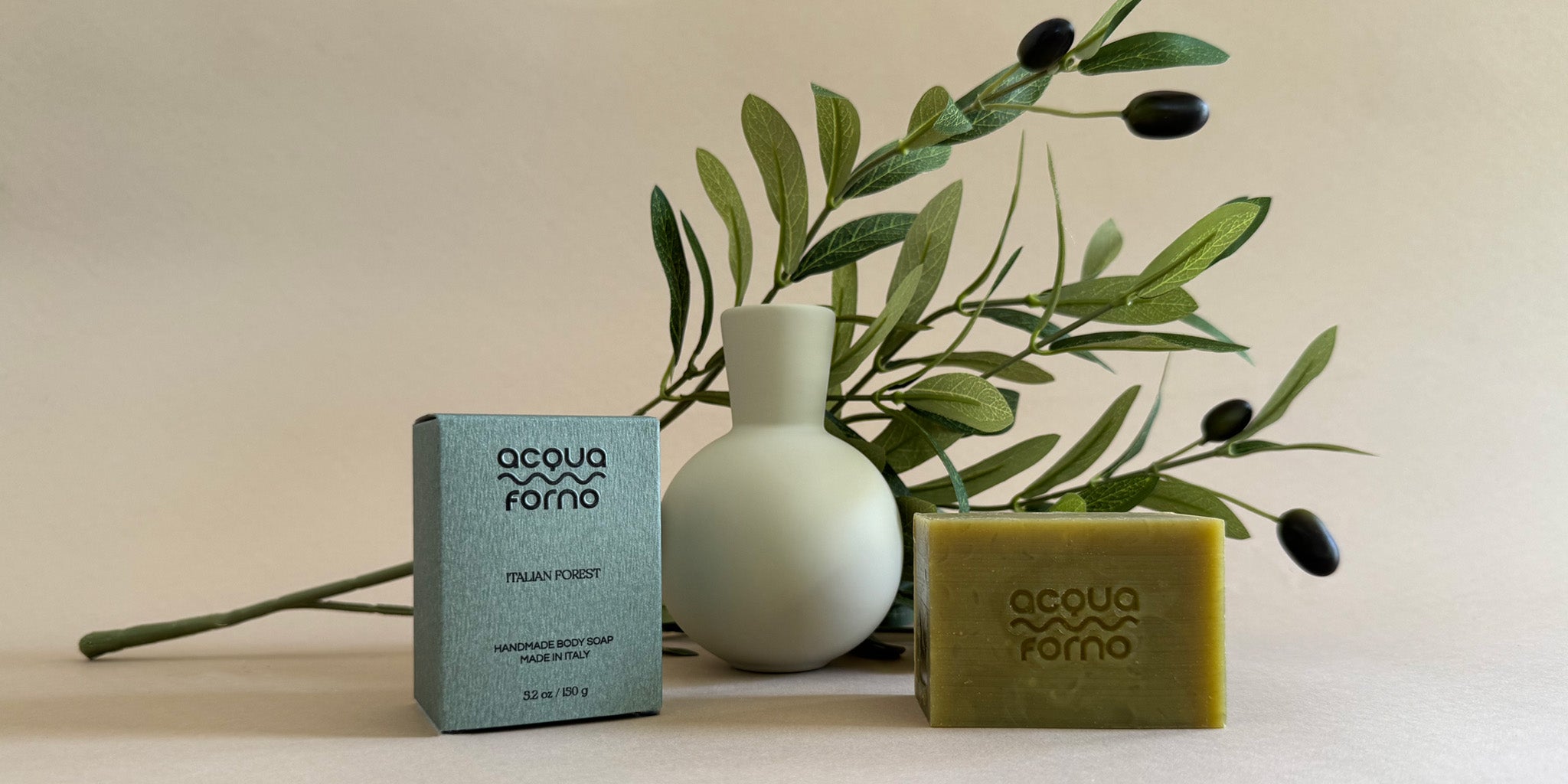 Green olive oil soap bar styled with a fresh olive branch, handmade in Italy