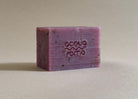 Close-up of cold process soap with rich texture, dark pink-red hue, infused with olive oil and blackberry