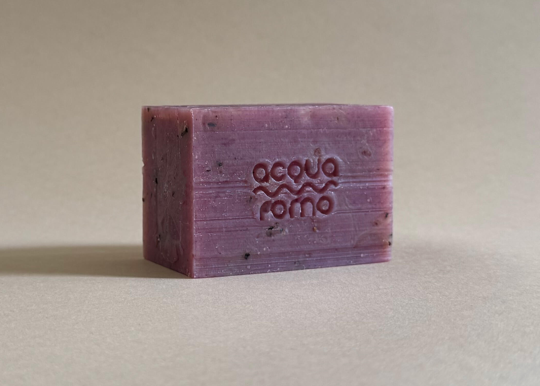 Close-up of cold process soap with rich texture, dark pink-red hue, infused with olive oil and blackberry